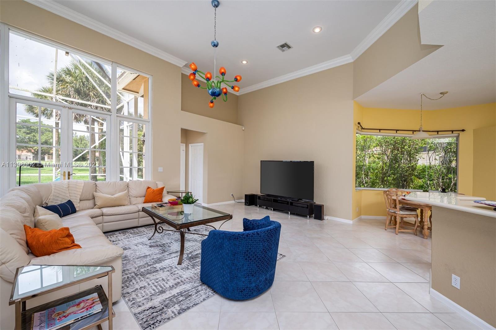 3155 Inverness Weston, FL 33332 - Photo 39 of 58 a living room with furniture a flat screen tv and a floor to ceiling window