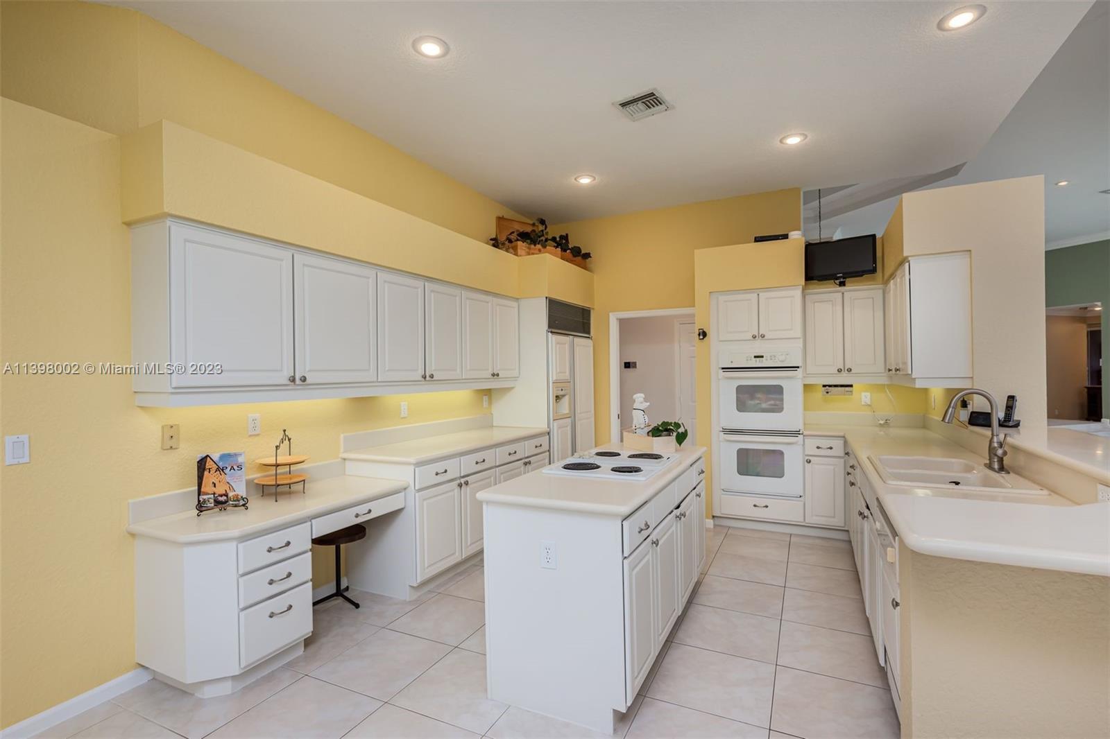 3155 Inverness Weston, FL 33332 - Photo 46 of 58 a kitchen with white cabinets sink and white appliances
