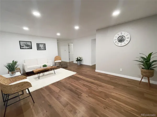 a living room with furniture and a wooden floor