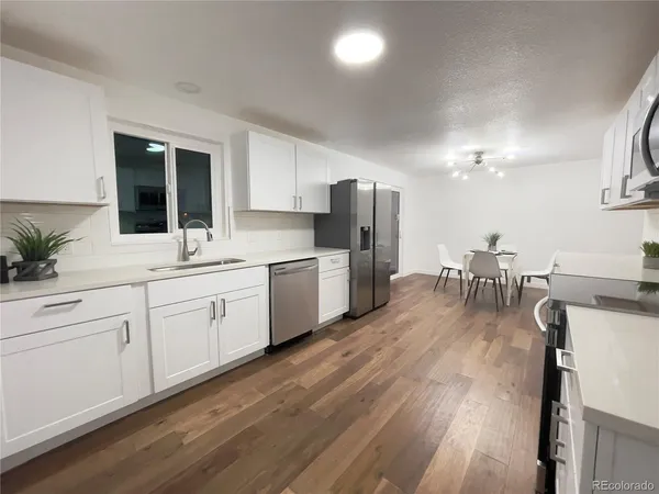a kitchen with a sink cabinets stainless steel appliances and dining table