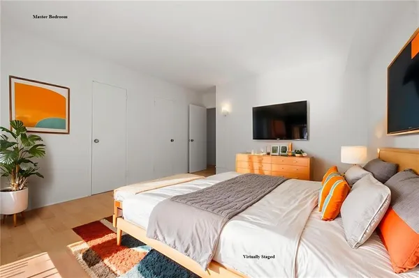 a bedroom with a bed and a flat screen tv