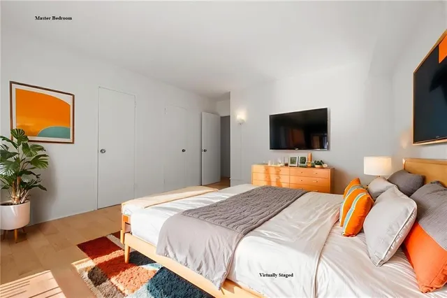 a bedroom with a bed and a flat screen tv