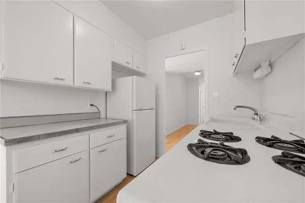 a kitchen with granite countertop a sink stove and cabinets