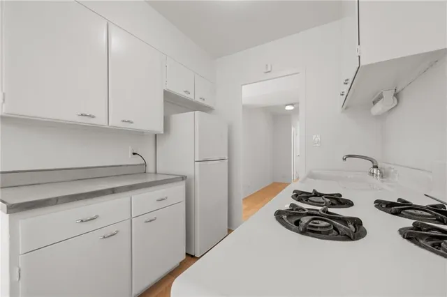 a kitchen with granite countertop a sink stove and cabinets