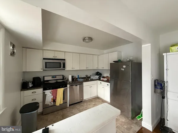a kitchen with stainless steel appliances granite countertop a refrigerator a stove top oven a sink and dishwasher
