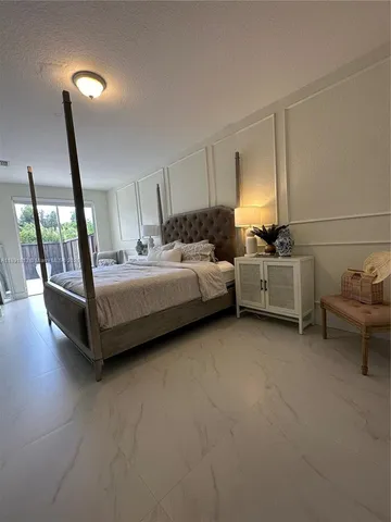 a spacious bedroom with a bed and large window