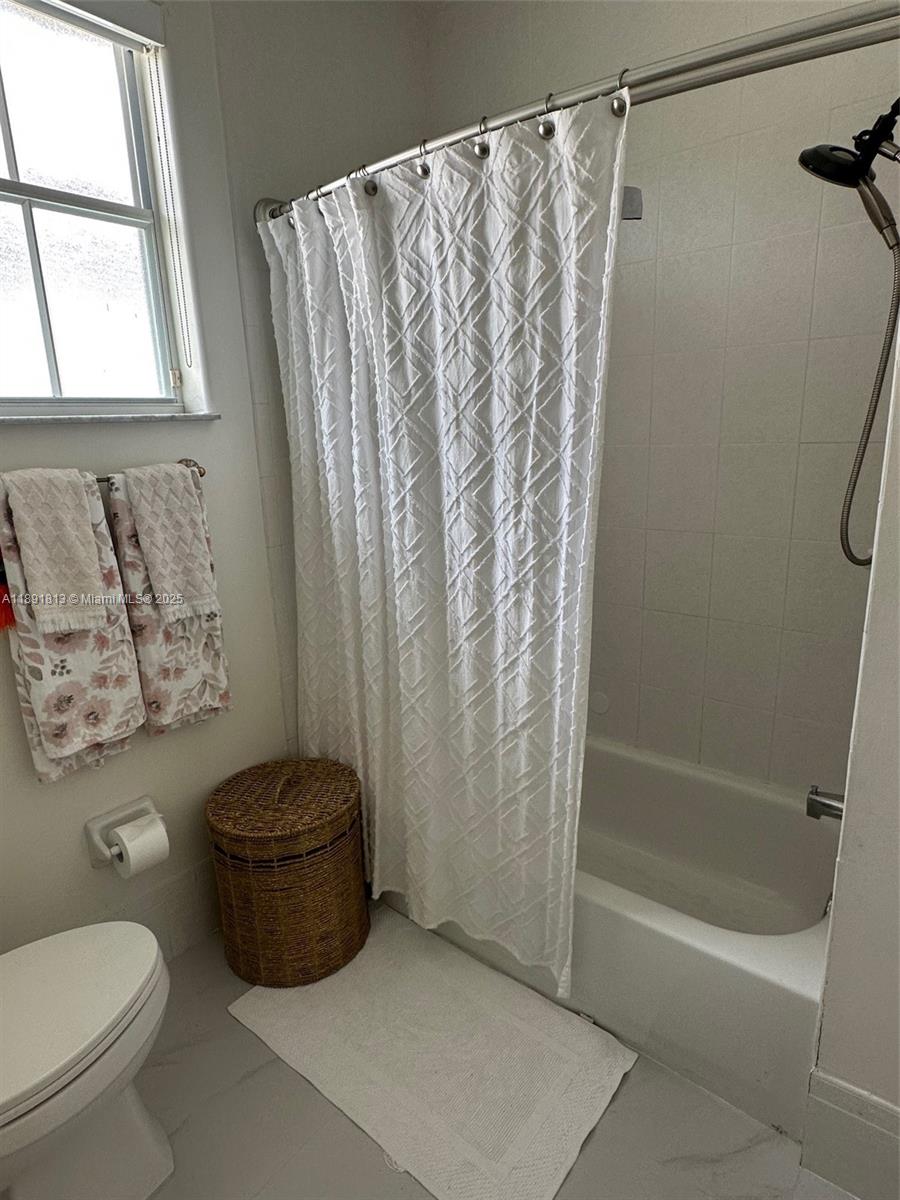 3744 Southwest 156th Court Miami, FL 33185 - Photo 9 of 10 a bathroom with a toilet and a shower curtain