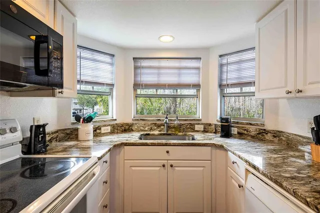 a kitchen with a sink stove top oven and cabinets