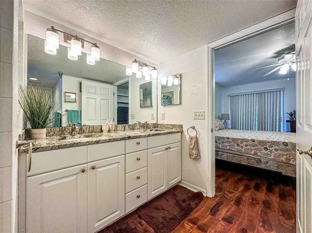 a bathroom with a granite countertop sink and a mirror