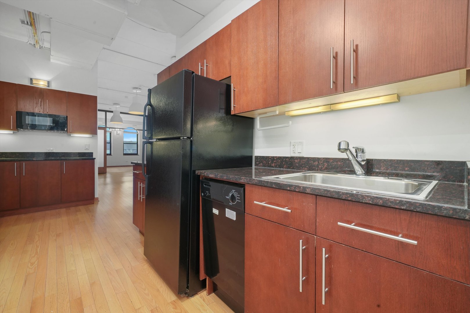 Undisclosed Address Chicago, IL 60654 - Photo 10 of 24 a kitchen with stainless steel appliances granite countertop a sink a refrigerator and a microwave
