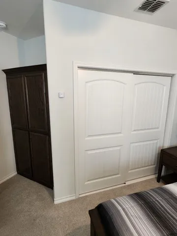 a bedroom with a bed a chandelier and a window