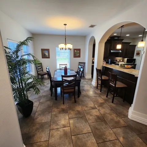 a view of a dining room with furniture and a chandelier