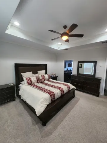 a spacious bedroom with a bed and a chandelier