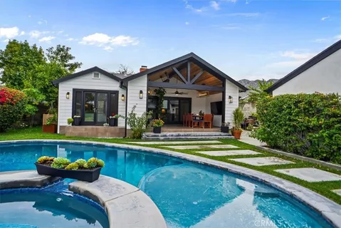a view of a house and swimming pool with a lounge chair