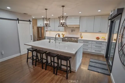 a kitchen with kitchen island a wooden floor and white appliances