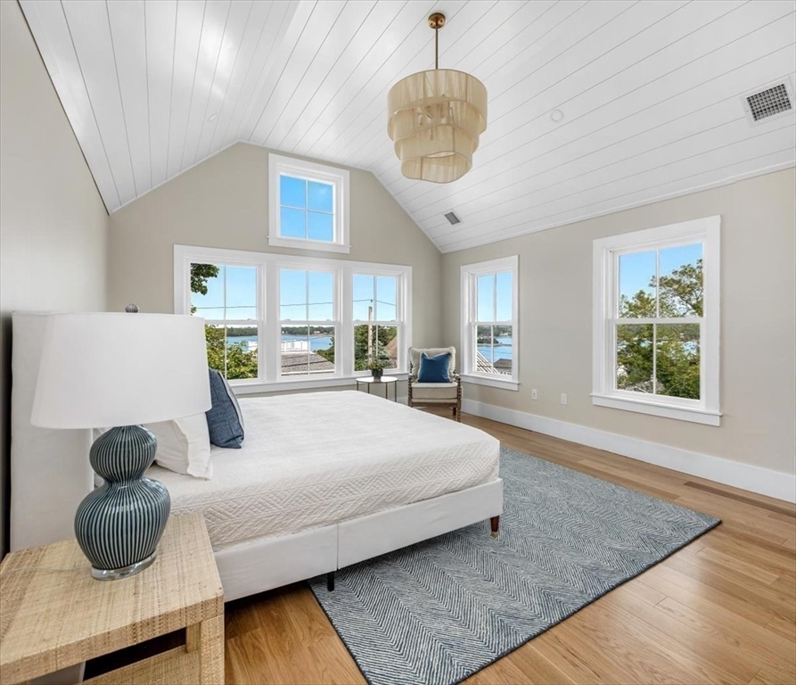 34 Otis Hill Road Hingham, MA 02043 - Photo 20 of 42 a bedroom with a large bed and a chandelier