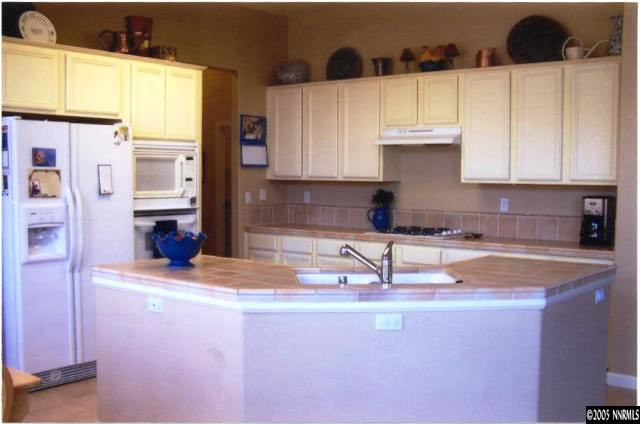 1525 Diamond Country Drive Reno, NV 89521 - Photo 5 of 6 a kitchen with stainless steel appliances granite countertop a sink a stove and a refrigerator