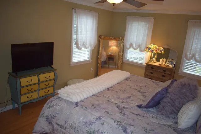 a bedroom with a bed and wooden floor