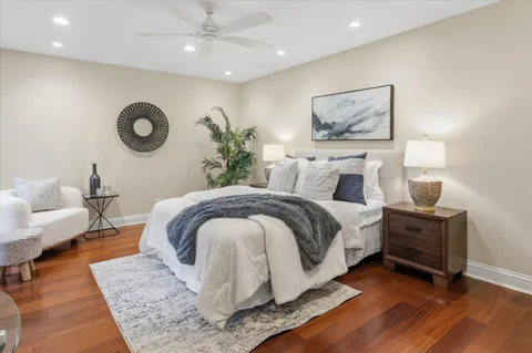 a spacious bedroom with a bed a couch and paintings on the wall