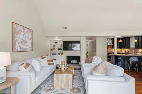 a living room with furniture a fireplace and a flat screen tv