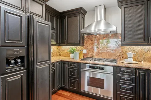 a kitchen with stainless steel appliances granite countertop a refrigerator and a sink