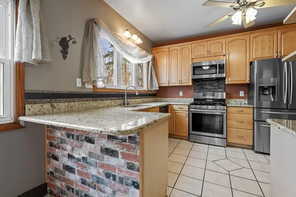 a kitchen with stainless steel appliances granite countertop a sink stove and refrigerator