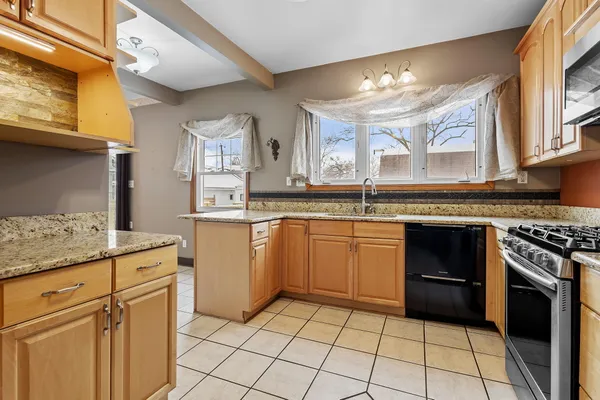 a kitchen with granite countertop cabinets stainless steel appliances and a counter space