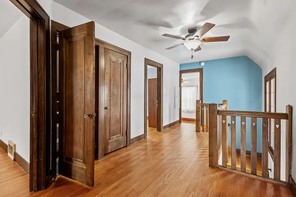 a view of a hallway with wooden floor and closet area