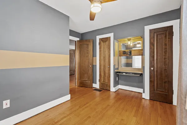an empty room with wooden floor and window