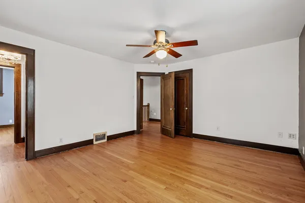 a view of a room with wooden floor and ceiling fan