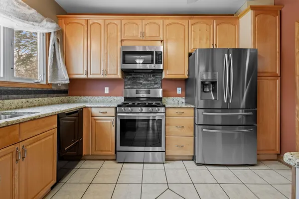a kitchen with granite countertop a refrigerator stove and microwave