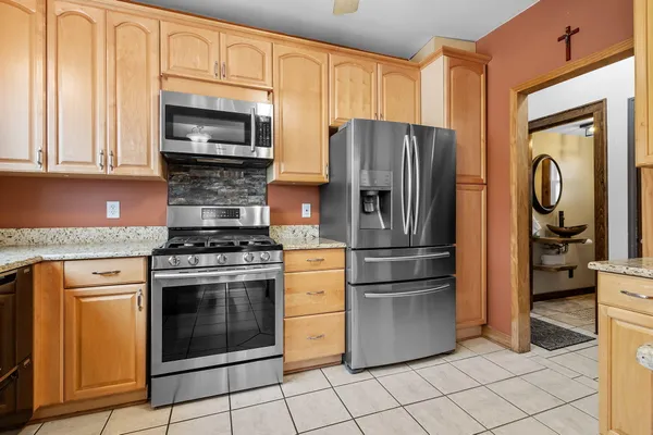 a kitchen with stainless steel appliances granite countertop a stove a refrigerator and a microwave