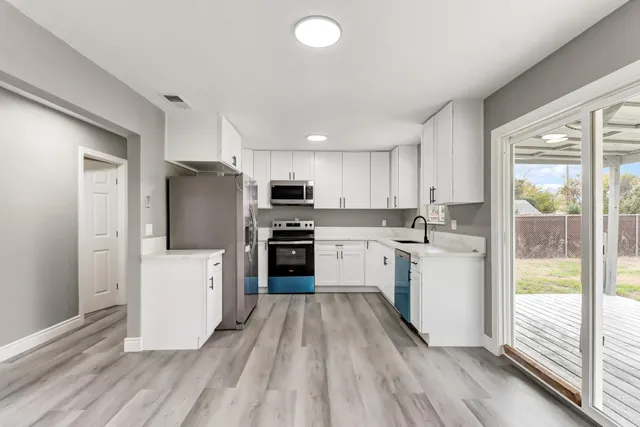 a kitchen with white cabinets and white appliances