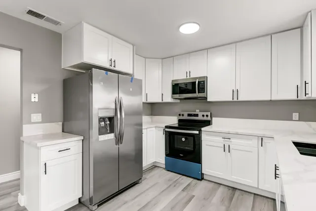 a kitchen with stainless steel appliances and wooden cabinets