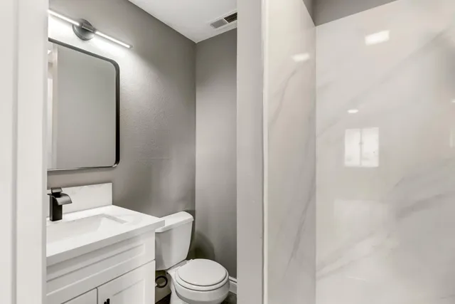 a white toilet sitting next to a bathroom sink