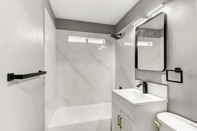 a bathroom with a sink toilet and shower