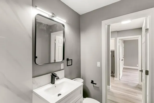 a bathroom with a toilet sink and mirror