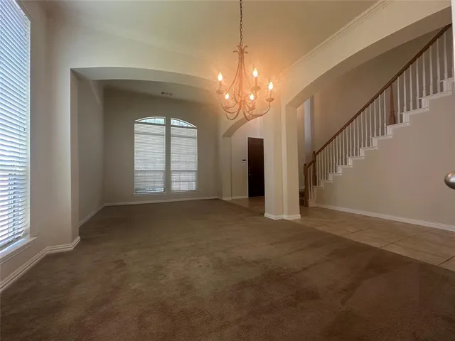 a view of a room with stairs and a chandelier