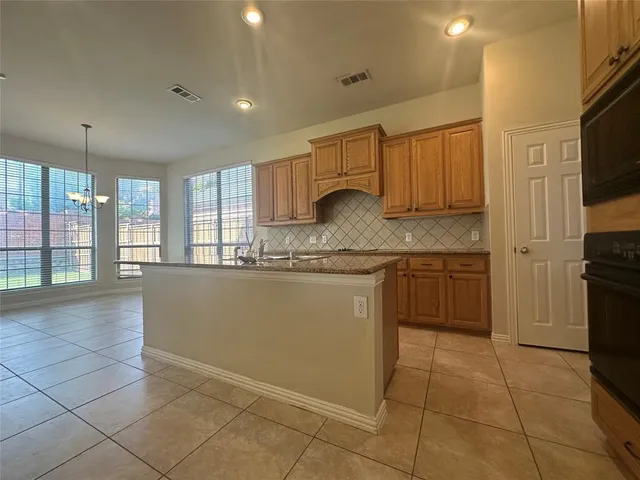 a kitchen with a sink a counter top space cabinets and stainless steel appliances