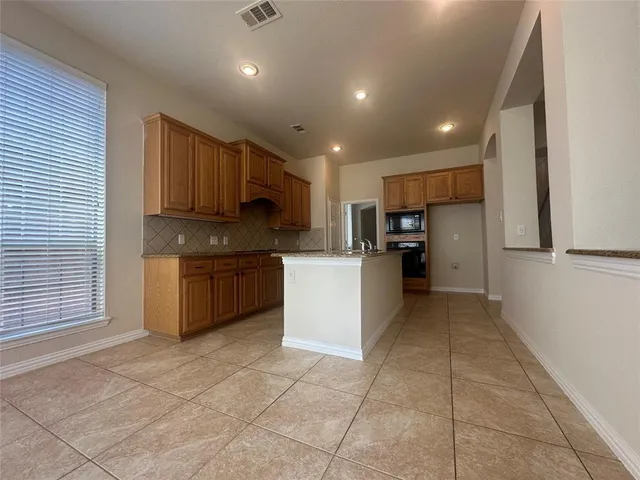 a kitchen with a refrigerator and a stove top oven
