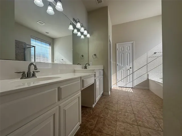 a spacious bathroom with a double vanity sink a mirror and a shower