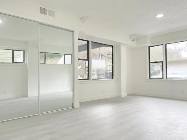 an empty room with windows and closet