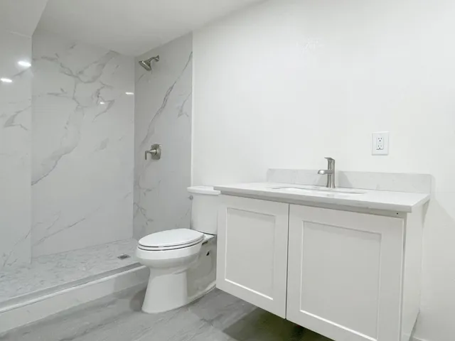 a bathroom with a sink a toilet and shower