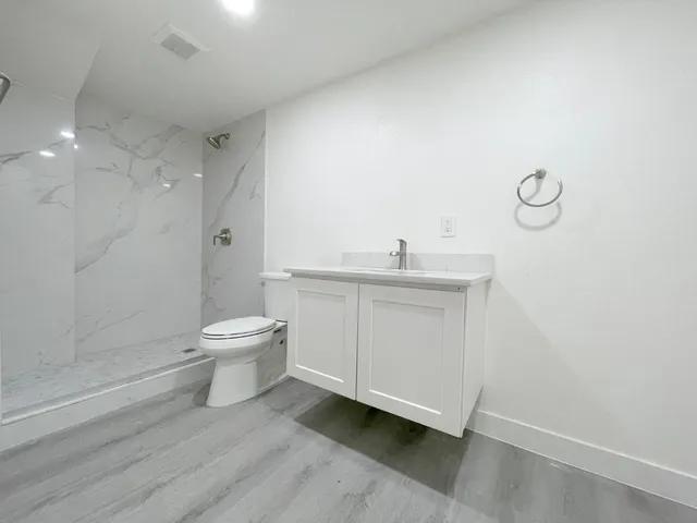 a bathroom with a toilet a sink and shower