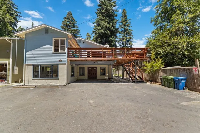 a view of a house with large windows and a small yard