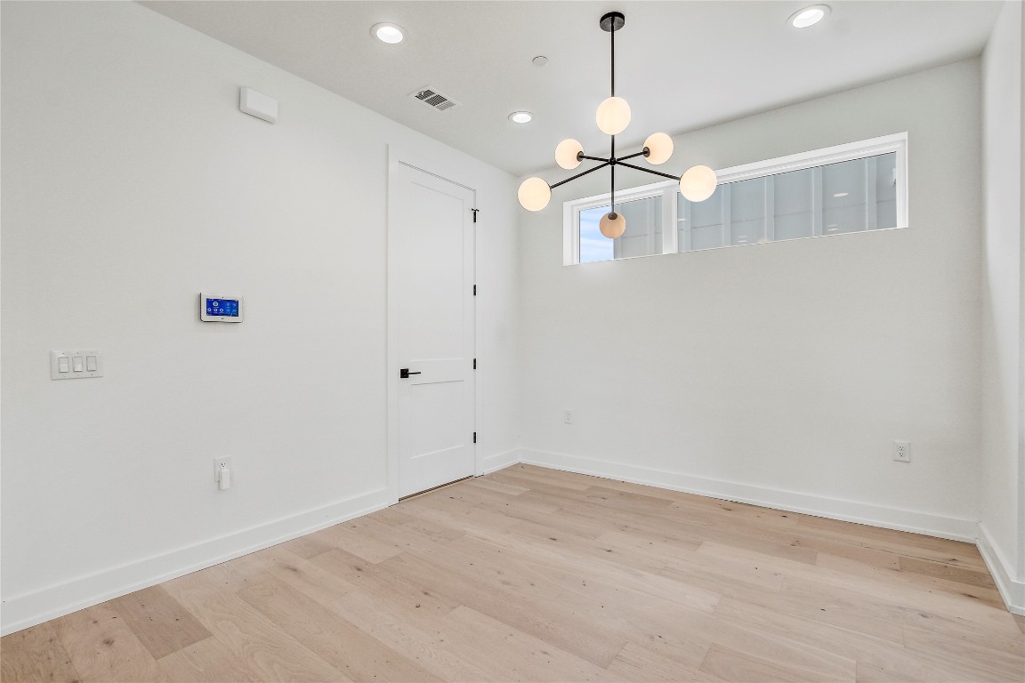 4127 East 12th Street, Unit 6 Austin, TX 78721 - Photo 14 of 17 Unfurnished room with a chandelier, light wood finished floors, recessed lighting, and baseboards