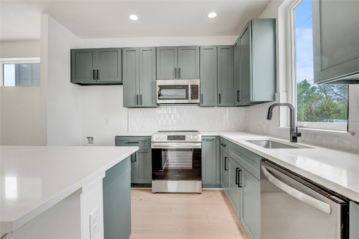 4127 East 12th Street, Unit 6 Austin, TX 78721 - Photo 7 of 17 Kitchen with stainless steel appliances, a sink, plenty of natural light, backsplash, and recessed lighting