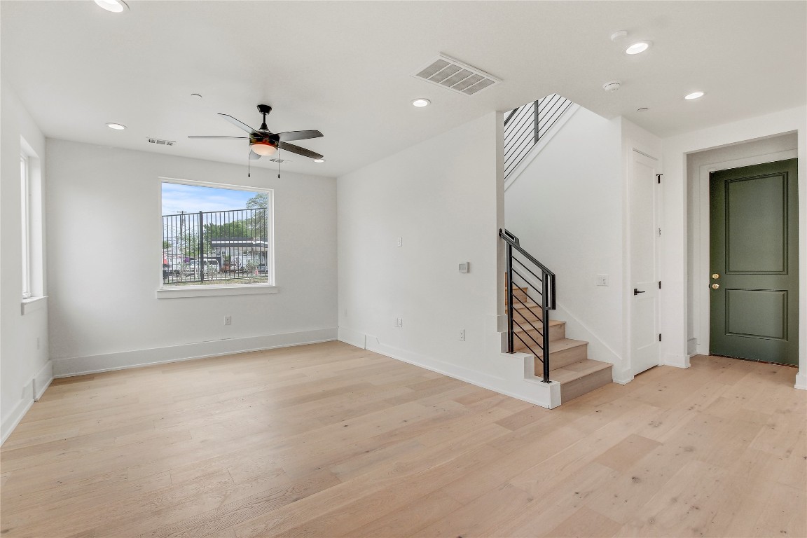 4127 East 12th Street, Unit 6 Austin, TX 78721 - Photo 10 of 17 Spare room featuring light wood-style floors, a ceiling fan, stairs, recessed lighting, and baseboards