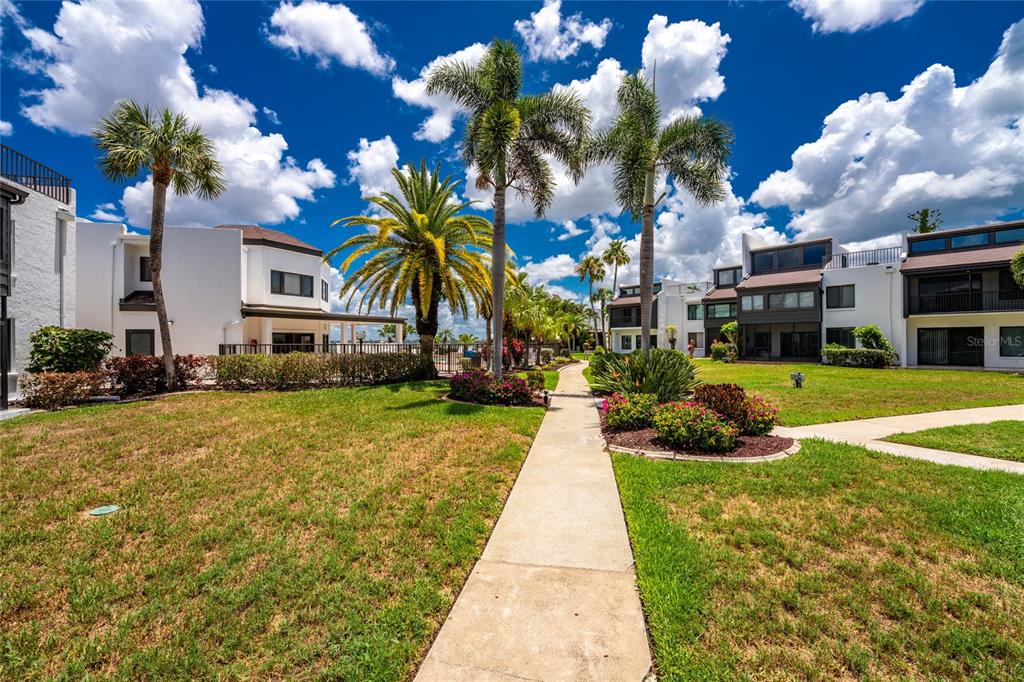 2955 North Beach Road, Unit B614 Englewood, FL 34223 - Photo 49 of 67 a front view of a building with garden and flowers