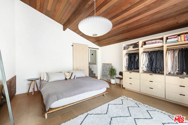 a bedroom with a bed and a large mirror on dresser